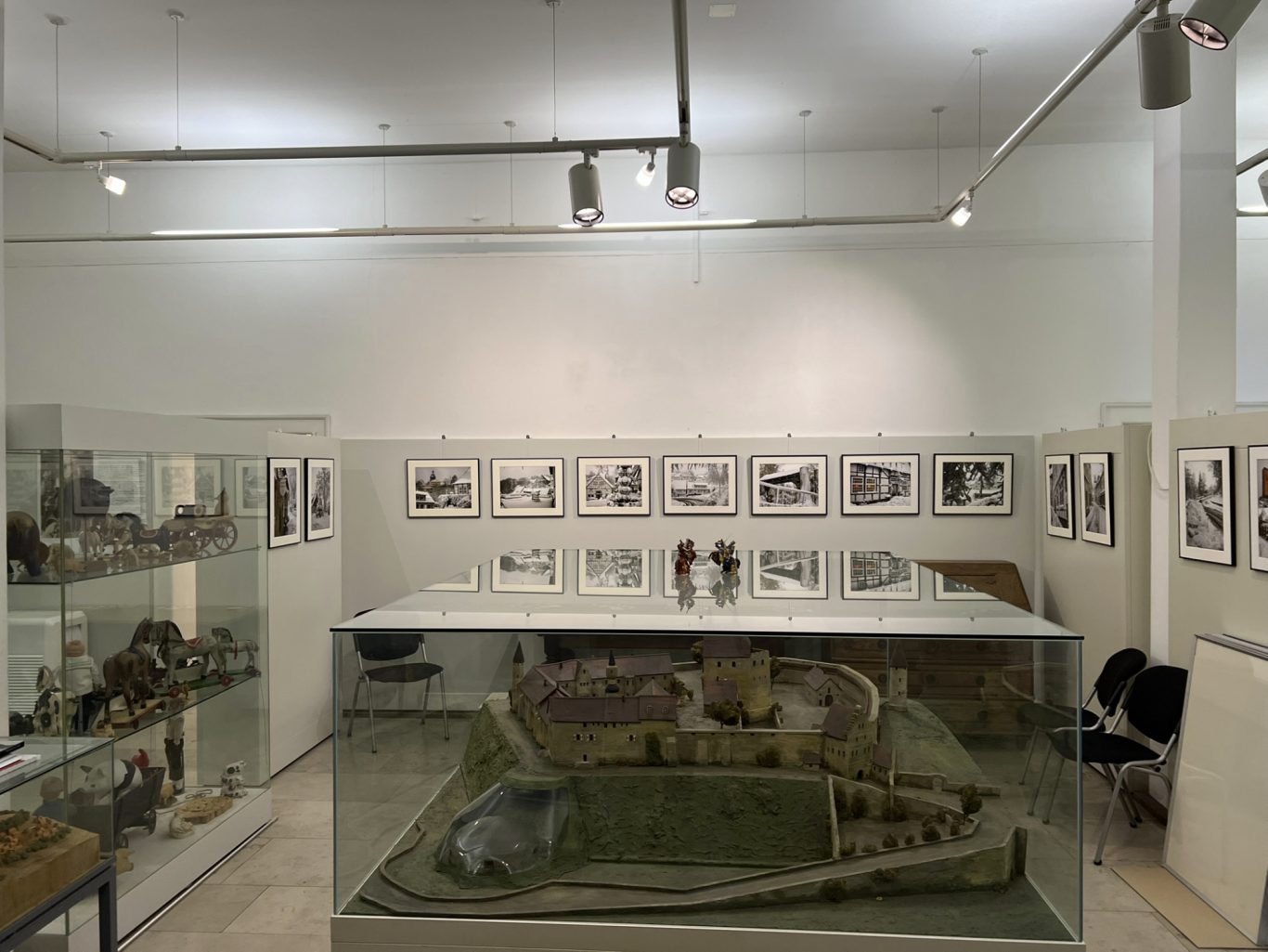 Fotoausstellung "Winter 2005" in Tecklenburg Ausstellungsraum mit Skulpturen, Fotografien und einem Diorama auf einem Tisch.